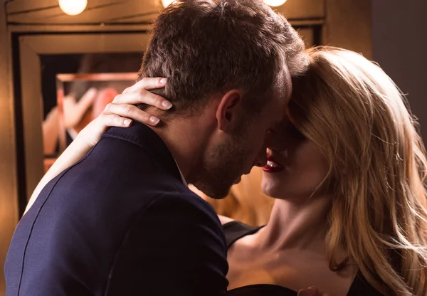 Sinnlicher Sex Date Moment: Mann hält Frau, kurz vor dem Kuss in gedämpftem Licht