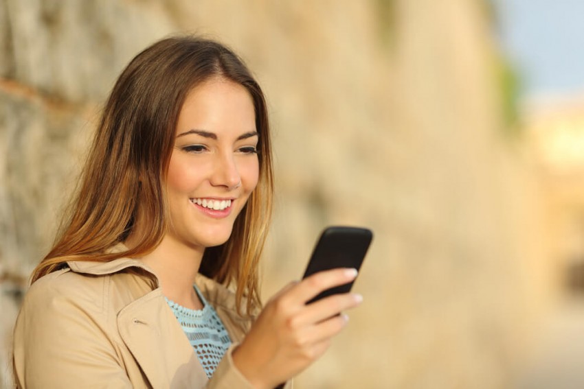 Attraktive Frau genießt schweizer Telefonsex über Smartphone – entspannter Sex Chat Schweiz beim Videotelefonsex unterwegs.