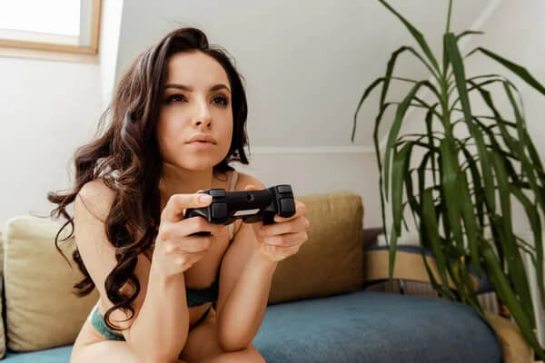 sexy mädchen mit gamepad spielen videospiele